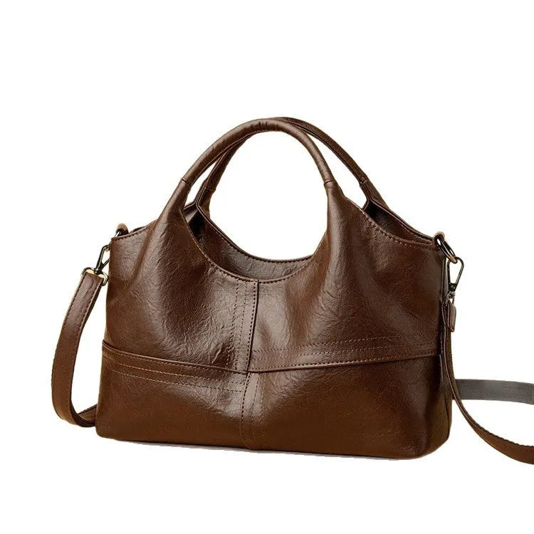 Soft leather crossbody handbag in black, bucket shape with single shoulder strap, lightweight design for women