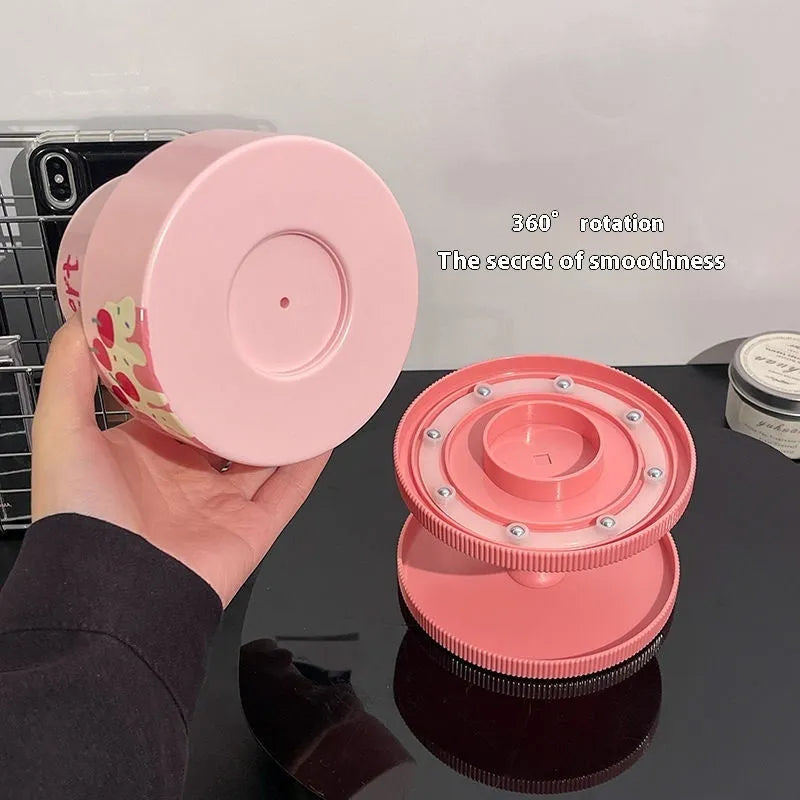 Rotating cosmetic brush storage barrel in a choice of colours on a table, showing its carousel design.