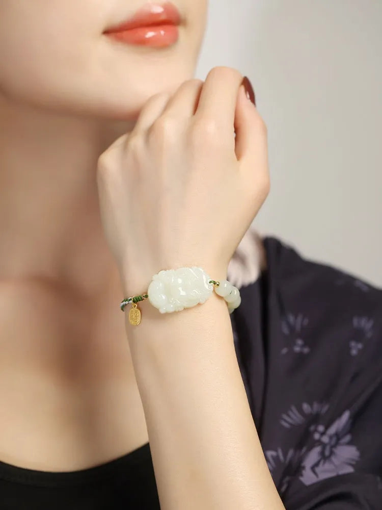 Hetian jade rabbit charm bracelet with sterling silver card on a white ice cotton rope.