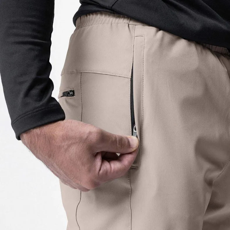 Man in loose grey fitness trousers with tied ankle cuffs, suitable for exercise.