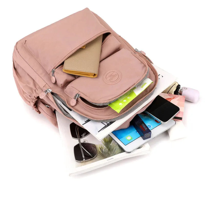 Women's large nylon travel backpack in celestite green showing front three-dimensional pocket and urban style.