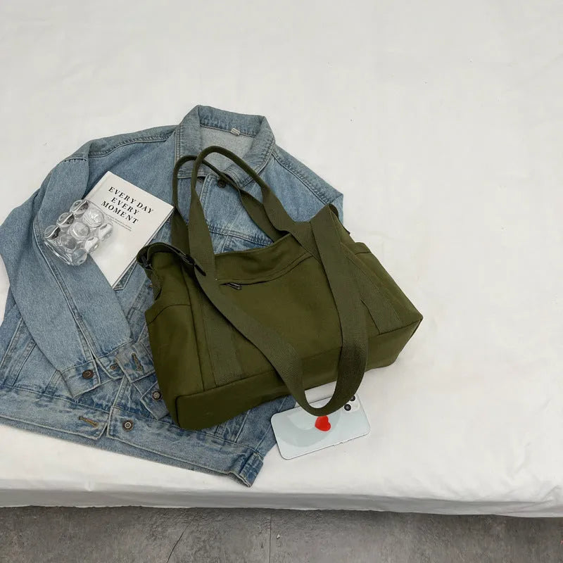 Polyester shoulder tote bag in solid colour with external sandwich pocket and internal phone pouch.