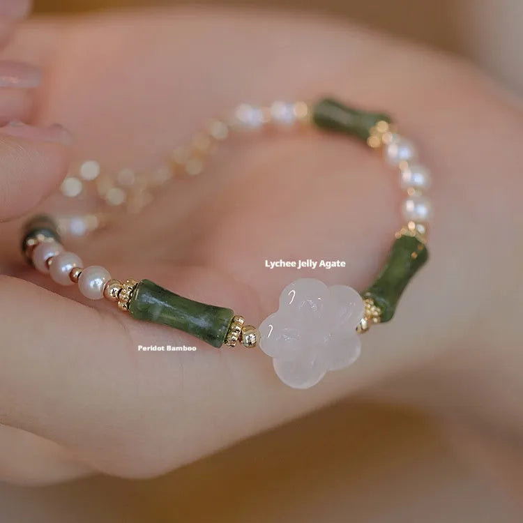 Handmade antique style bracelet with Hetian jade, copper shell pearls, and bamboo joint detail.