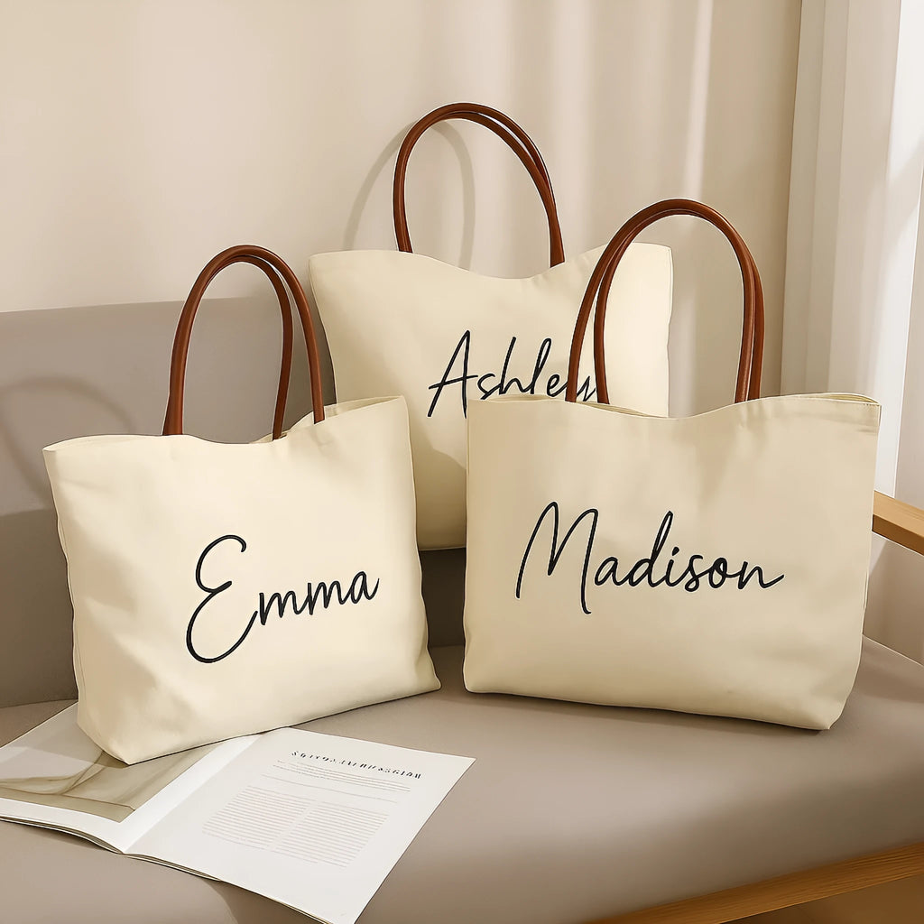 Beige white canvas tote bag with top handles and an internal zip pocket, shown with a book and keys.