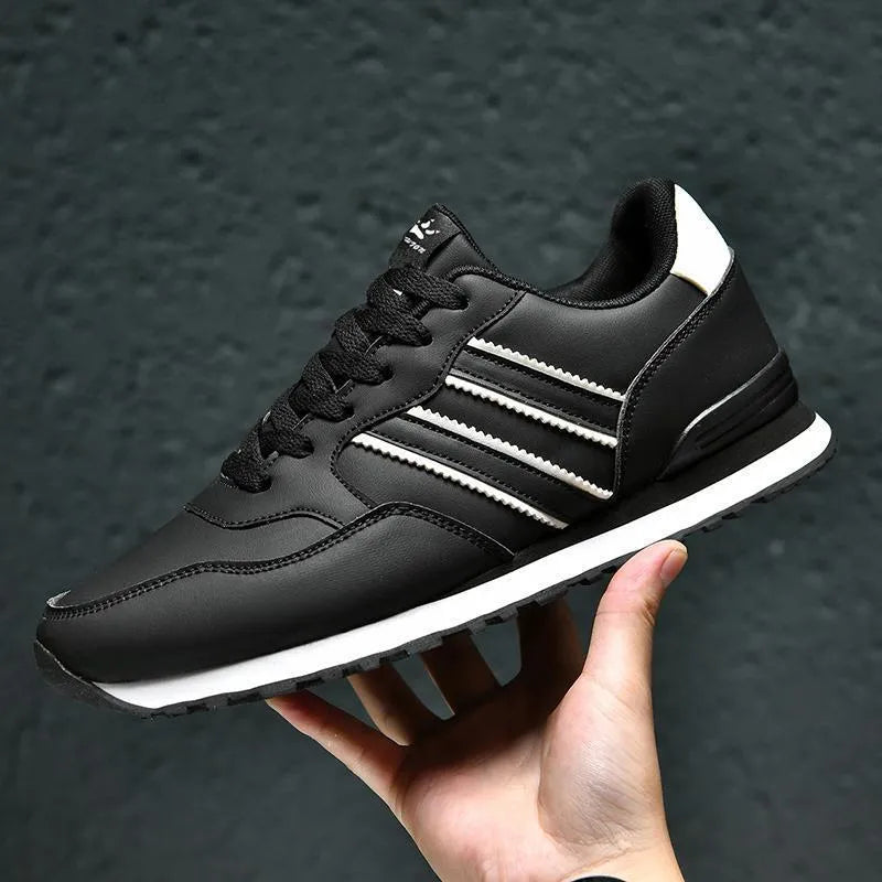 Men's black casual running shoes with a white carved wing pattern on the leather upper.
