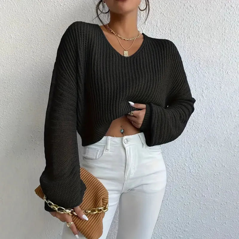 A woman's loose-fitting long sleeve pullover top in a solid colour.