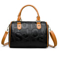 Brown cylindrical crossbody bag with three straps on a plain background