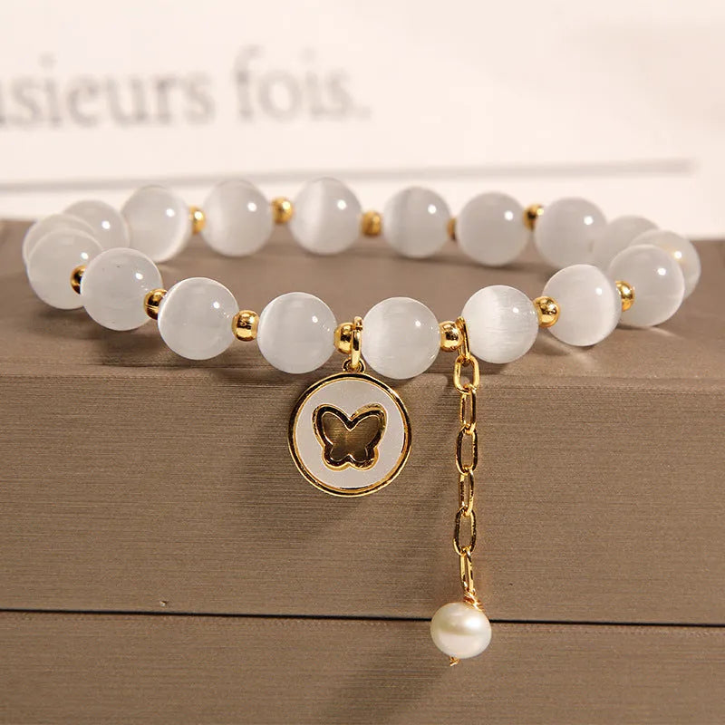 White geometric cat's eye crystal bracelet with a Korean-style design on a wrist.