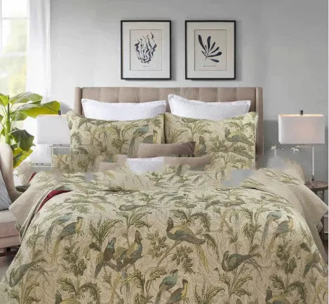 Blue American floral and bird pattern quilted cotton bedspread set laid on a bed.