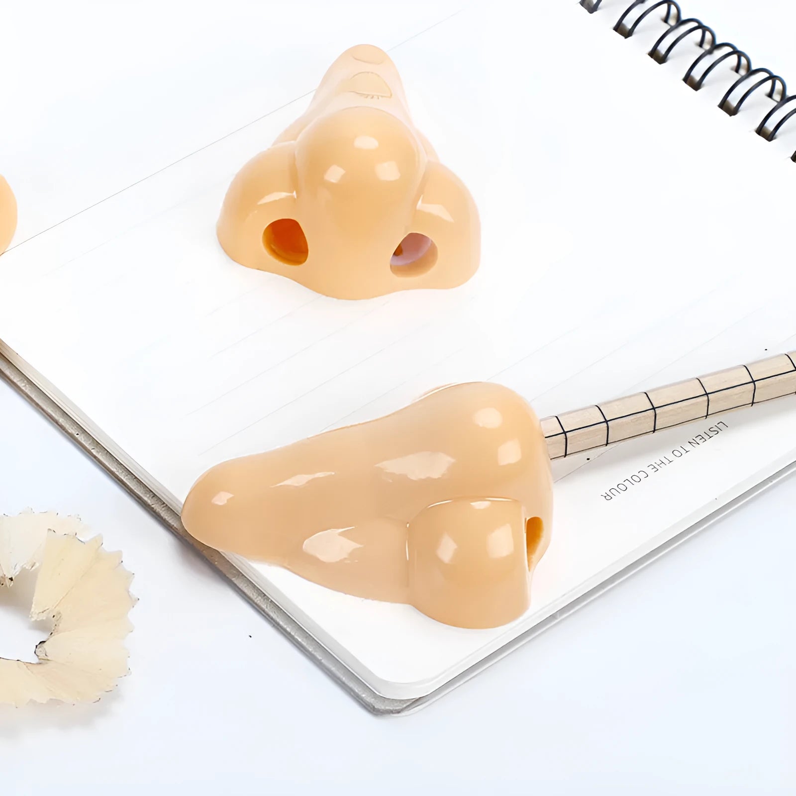 Flesh-coloured geometric pencil sharpener with a big hole for large pencils on a white background.