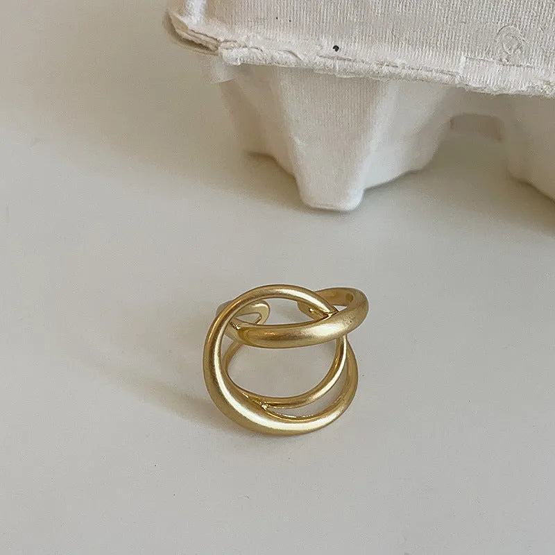 Women's geometric open ring with three-dimensional interlaced matte metal design in gold or silver with real gold electroplating