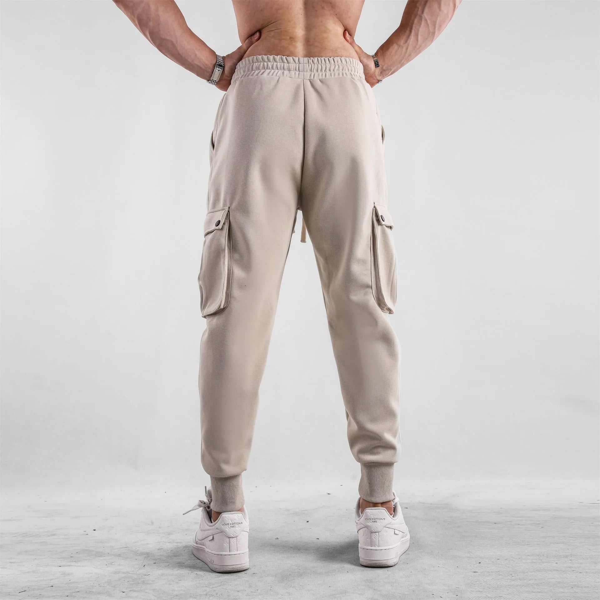 Men's loose cotton ankle-tied sport trousers in a solid colour with multiple pockets.
