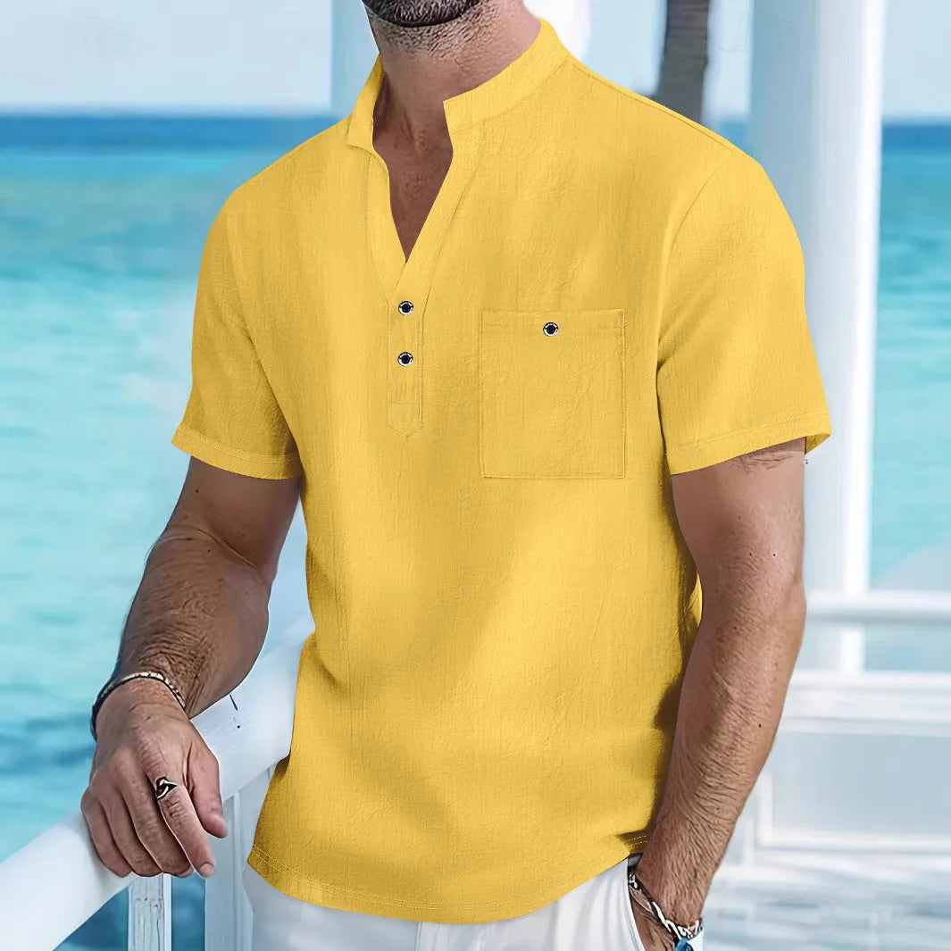 A man wearing a light blue linen stand collar short-sleeve shirt, showing the loose fit and structured neckline.
