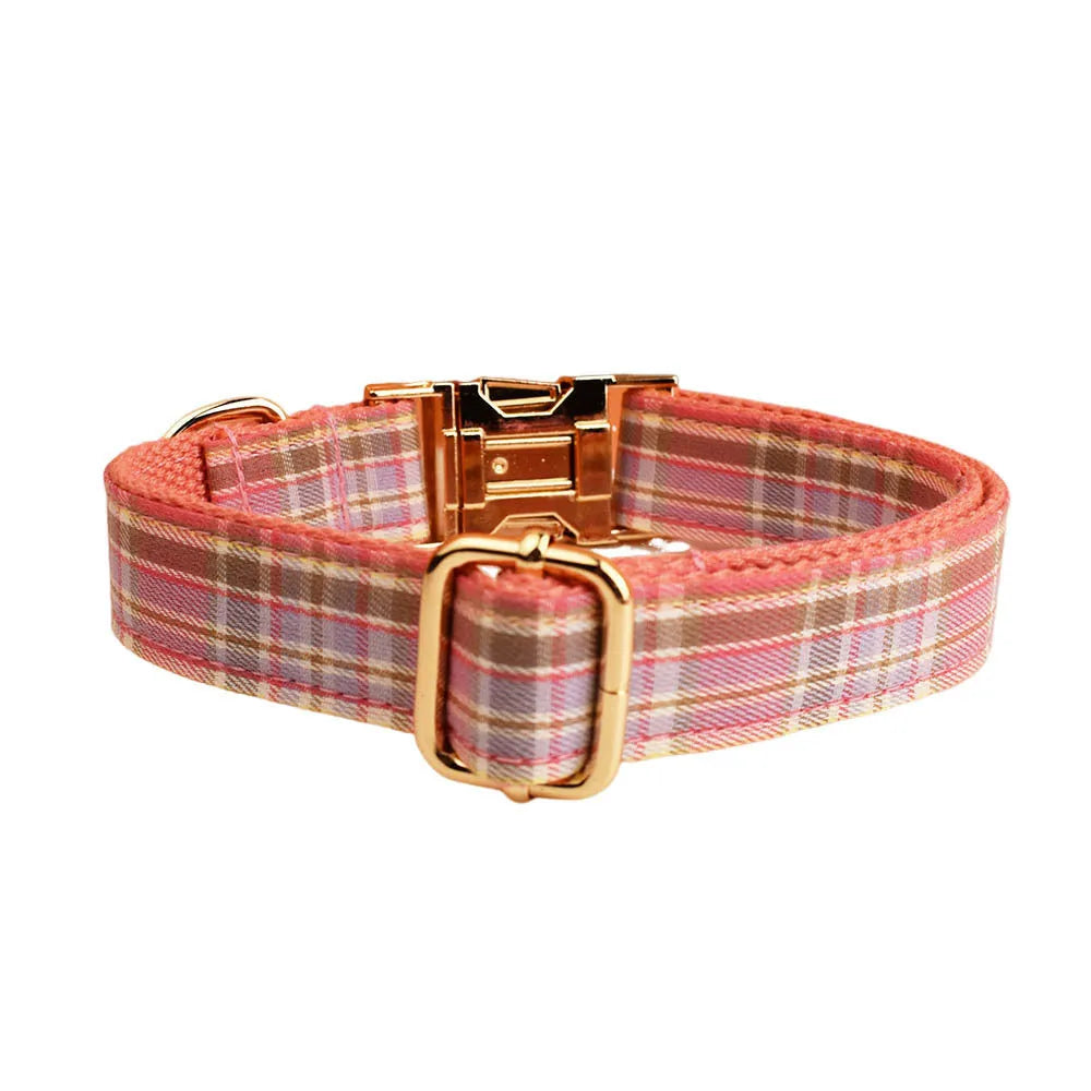 Plaid fabric dog collar, leash, bow, and vest four-piece accessory set on a white background.