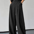 Men's black vertical striped pleated casual trousers showing elasticated waist and leg detail