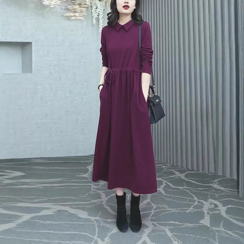 A purplish red long sleeve plus size dress for women, shown with extra-long sleeves and a long skirt.