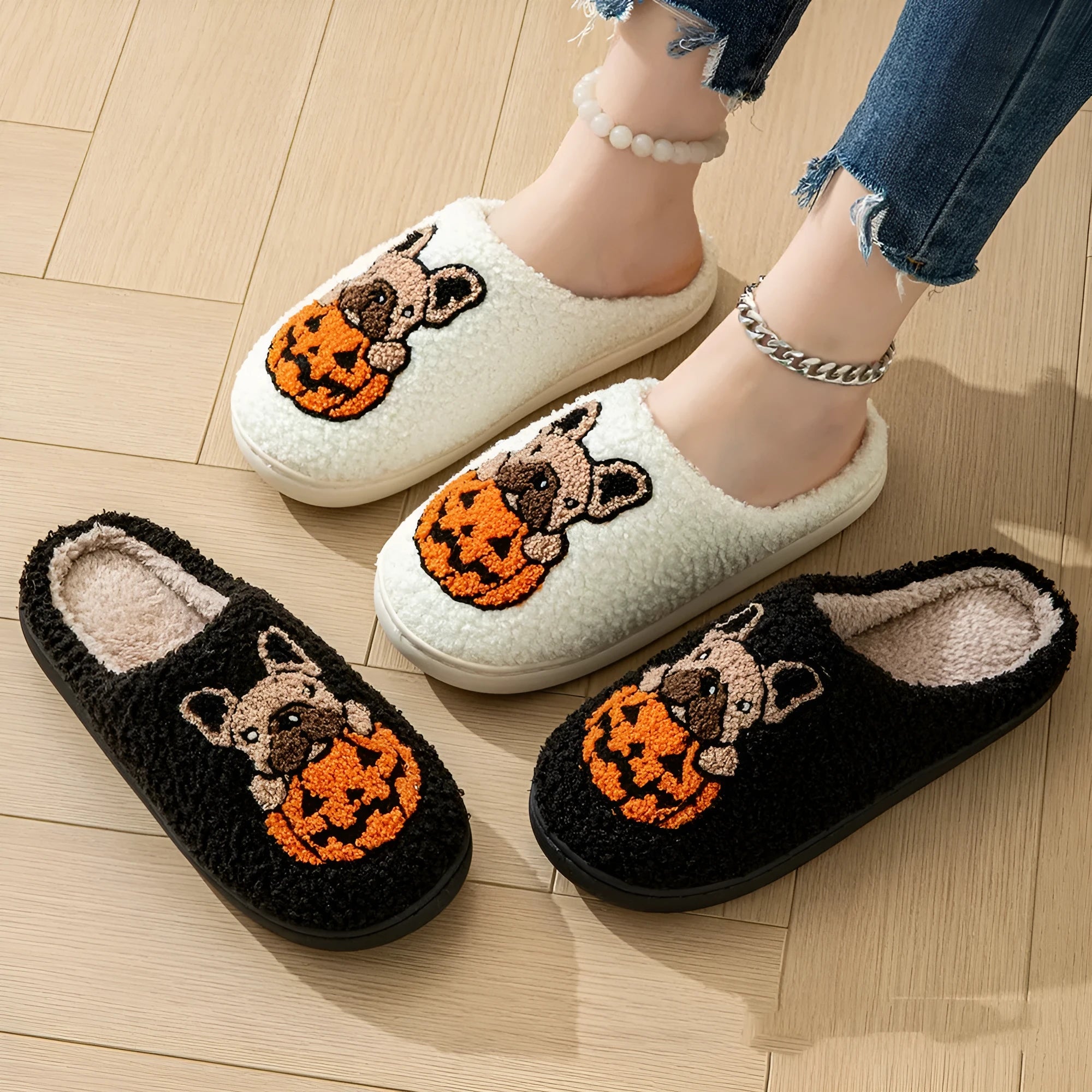 Black and white Halloween pumpkin plush house slippers with non-slip rubber soles.