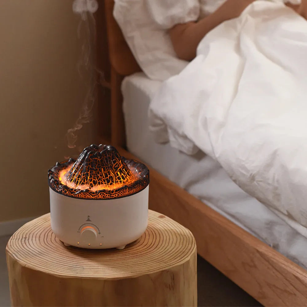 Small white volcano-shaped humidifier with simulated flame lighting and remote control on wooden table