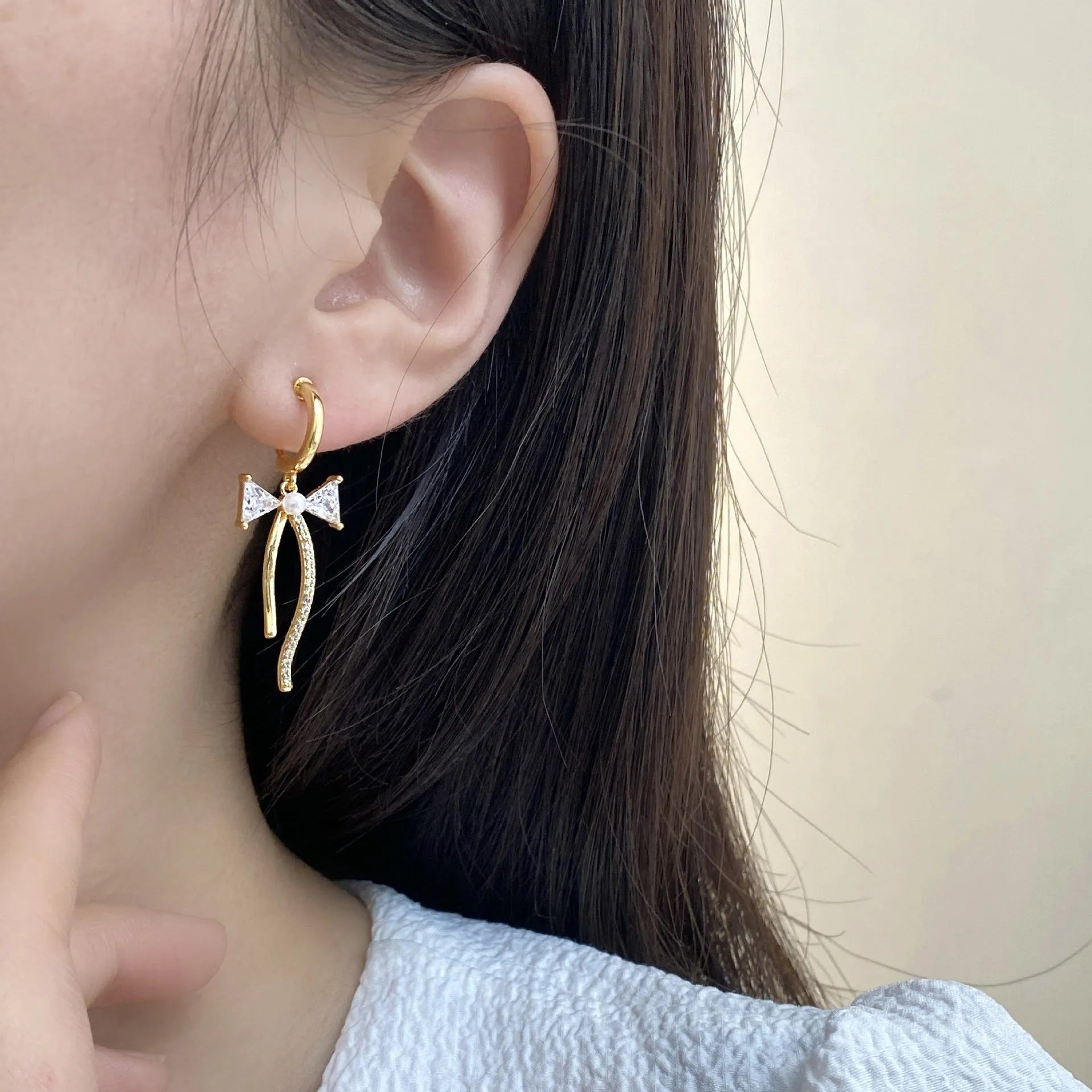 Asymmetric micro-set zirconia C-shaped light luxury earrings in copper, ear clip style on a woman