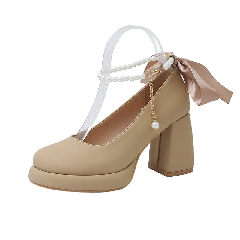 Women's beige Mary Jane shoes with a chunky heel and an adjustable ankle strap buckle.