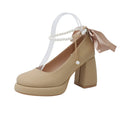 Women's beige Mary Jane shoes with a chunky heel and an adjustable ankle strap buckle.