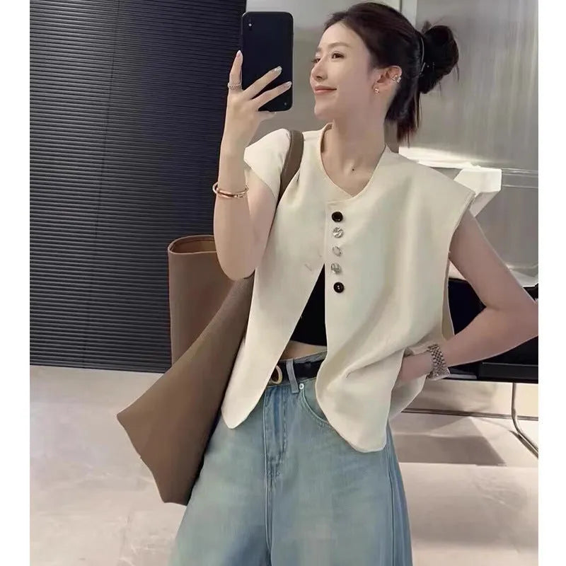 Women's loose fit polyester vest in milky white with a pocket detail and short 40cm length.