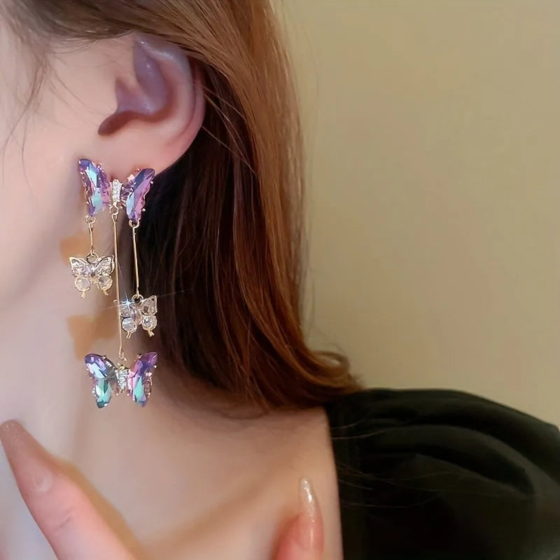 A pair of blue purple butterfly coloured alloy earrings with crystal flowers and a drop tassel.