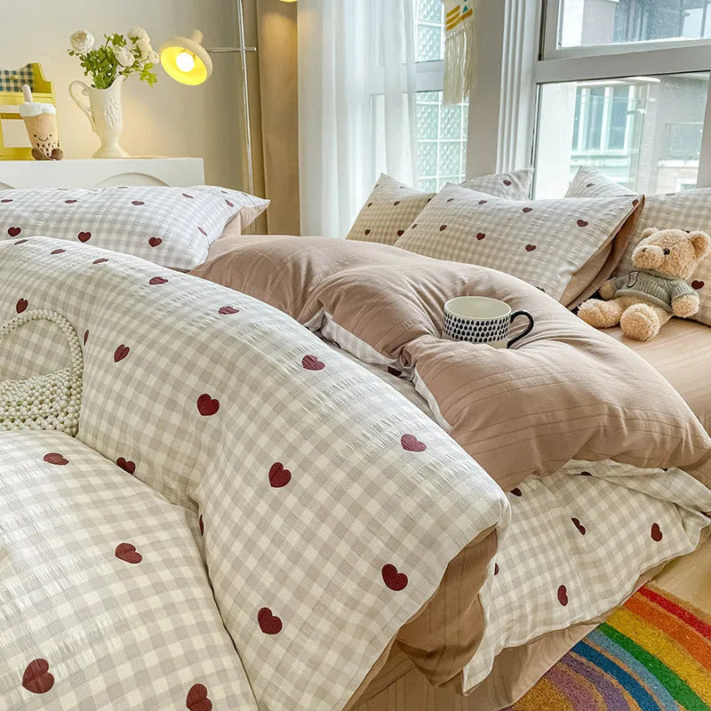 Aerobic jacquard cloud yarn four-piece bedding set with quilt cover, sheet, and pillowcases in a soft pattern.