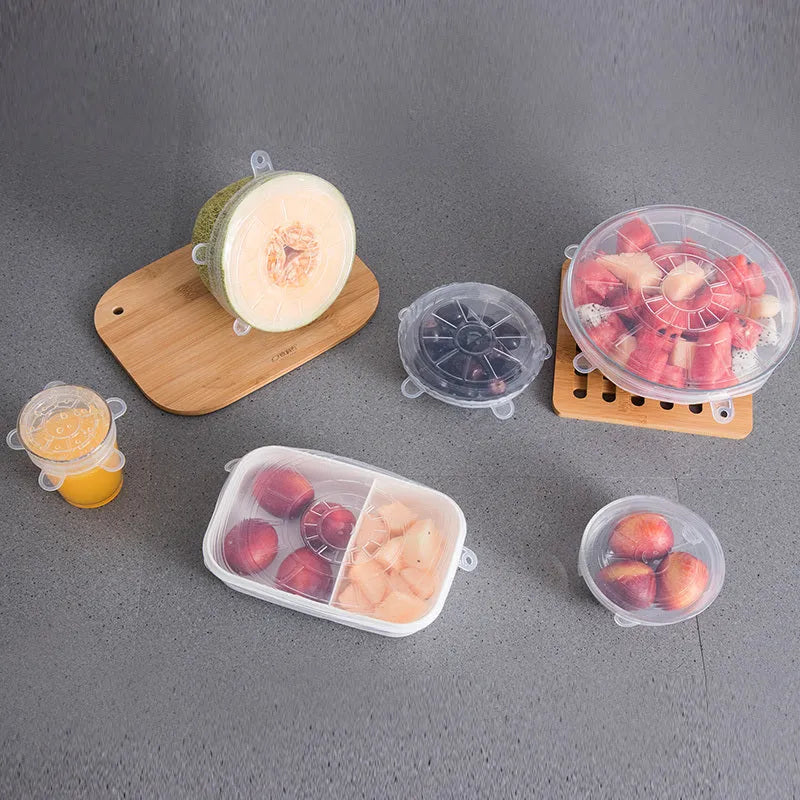 Set of six colourful silicone stretch lids in different sizes arranged on a kitchen counter.