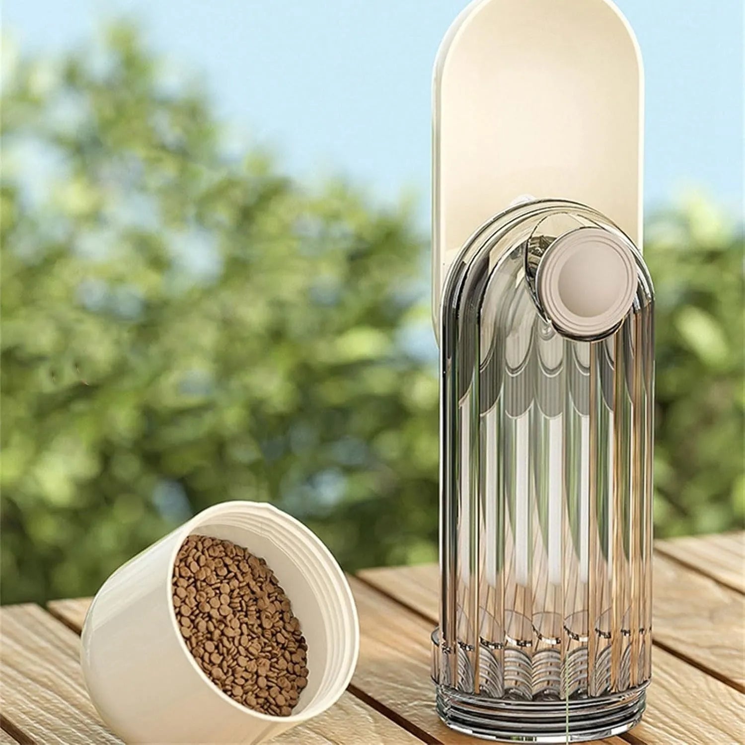 Beige dog water bottle with foldable silicone tray and integrated food dispenser base.