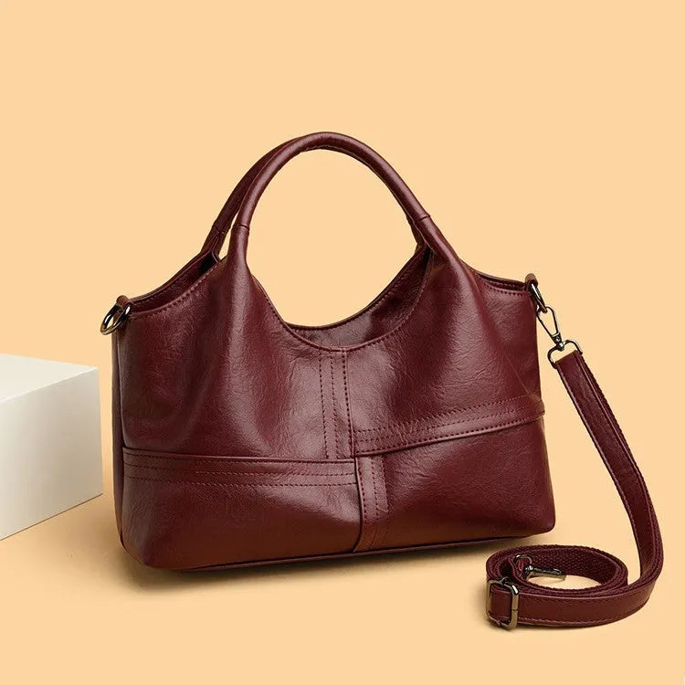 Soft leather crossbody handbag in black, bucket shape with single shoulder strap, lightweight design for women