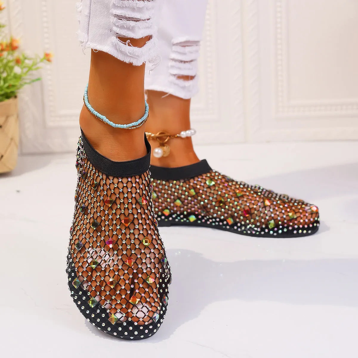 Women's flat sandals with mesh upper, colourful rhinestone design, and round toe on a rubber sole.