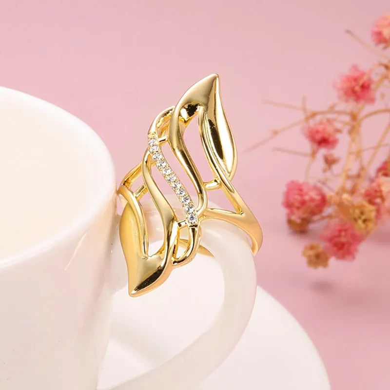 Gold-coloured copper women's ring with exaggerated curve design on finger