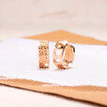 A pair of circular rose gold women's earrings with a three-heart hollowed-out design.