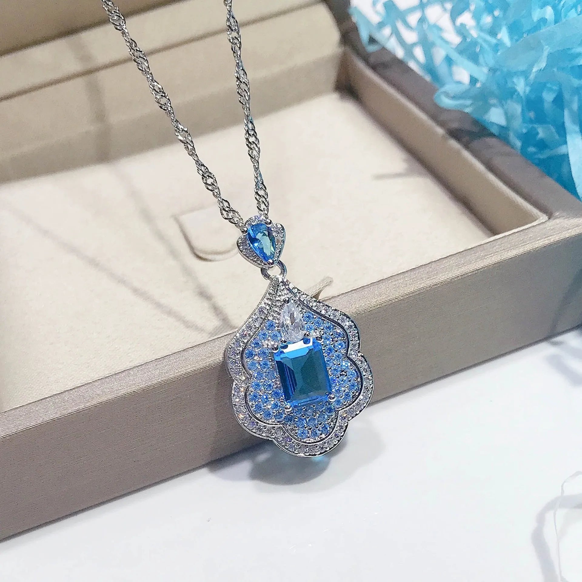 Sea blue geometric copper pendant charm with aquamarine topaz design, shown without a chain.