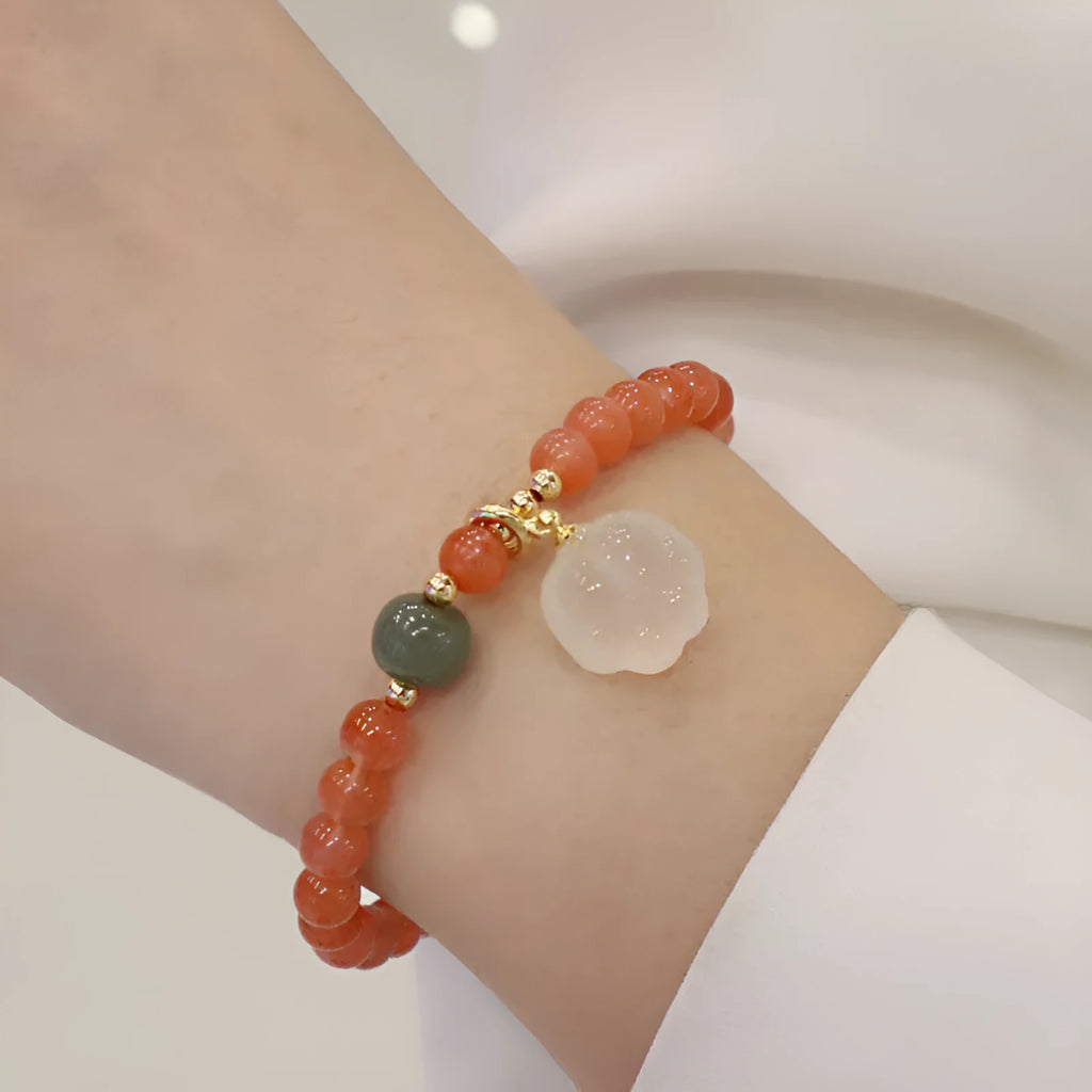 Natural red agate bracelet with jade beads and a Cat's Paw charm, showing 8mm agate beads and gem inlay detail.