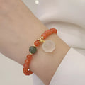 Natural red agate bracelet with jade beads and a Cat's Paw charm, showing 8mm agate beads and gem inlay detail.
