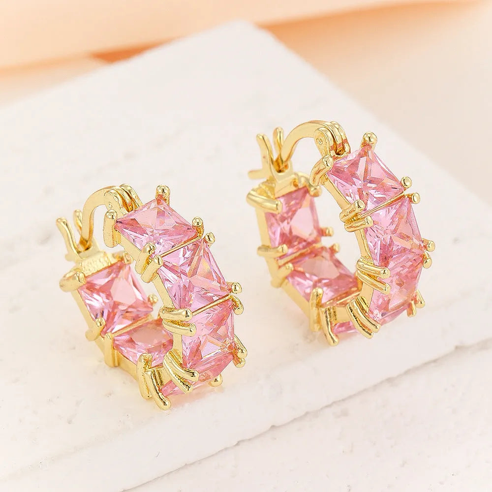 Geometric U-shaped gold earrings with a round black crystal zircon stone.