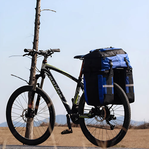 Green bicycle rear storage bag with 70 litre capacity mounted on a bike rack for touring.