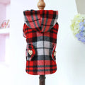 Red plaid trench coat for a dog, shown alongside a black houndstooth version, on a mannequin.