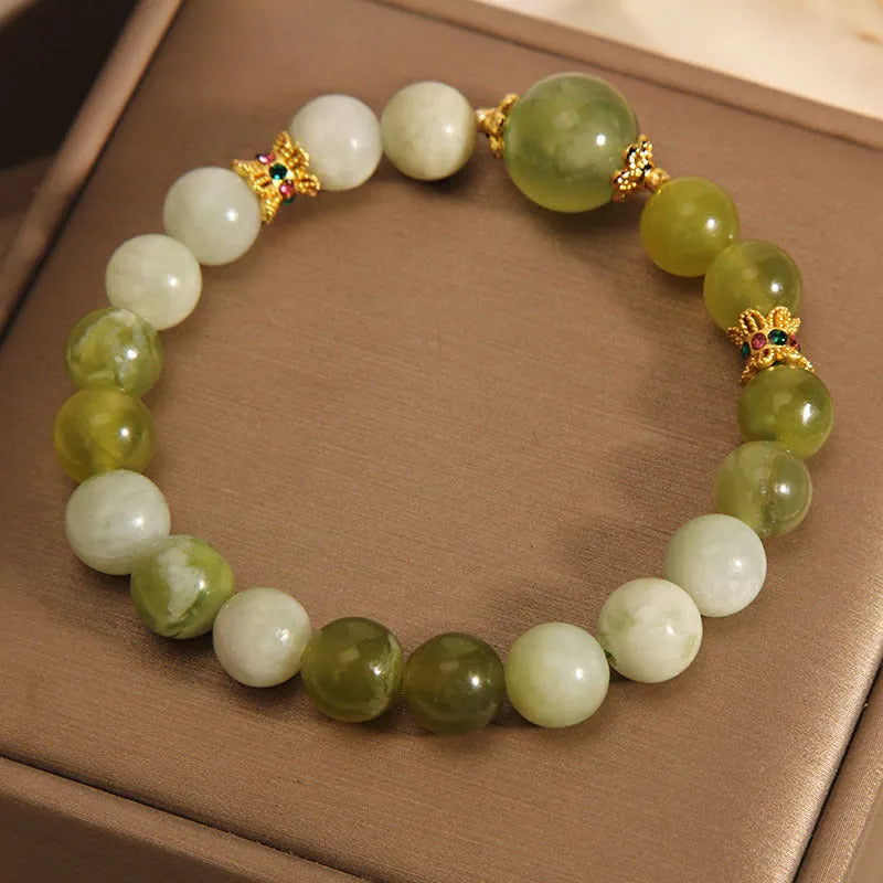 Women's solid Xiuyan jade bracelet in a green colour, shown as a single smooth bead.
