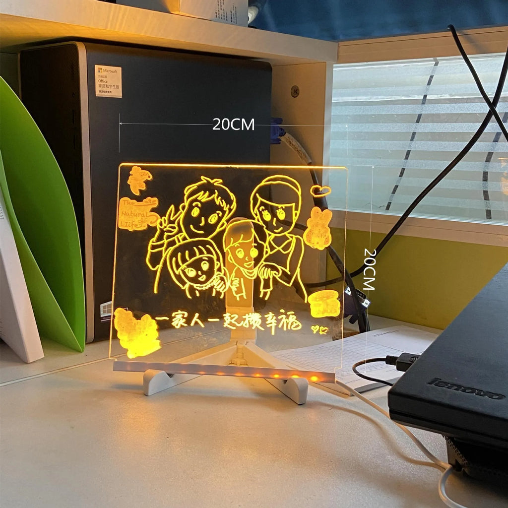 Acrylic DIY LED message board night light on a desk, showing writing on the glowing transparent surface with pens nearby.