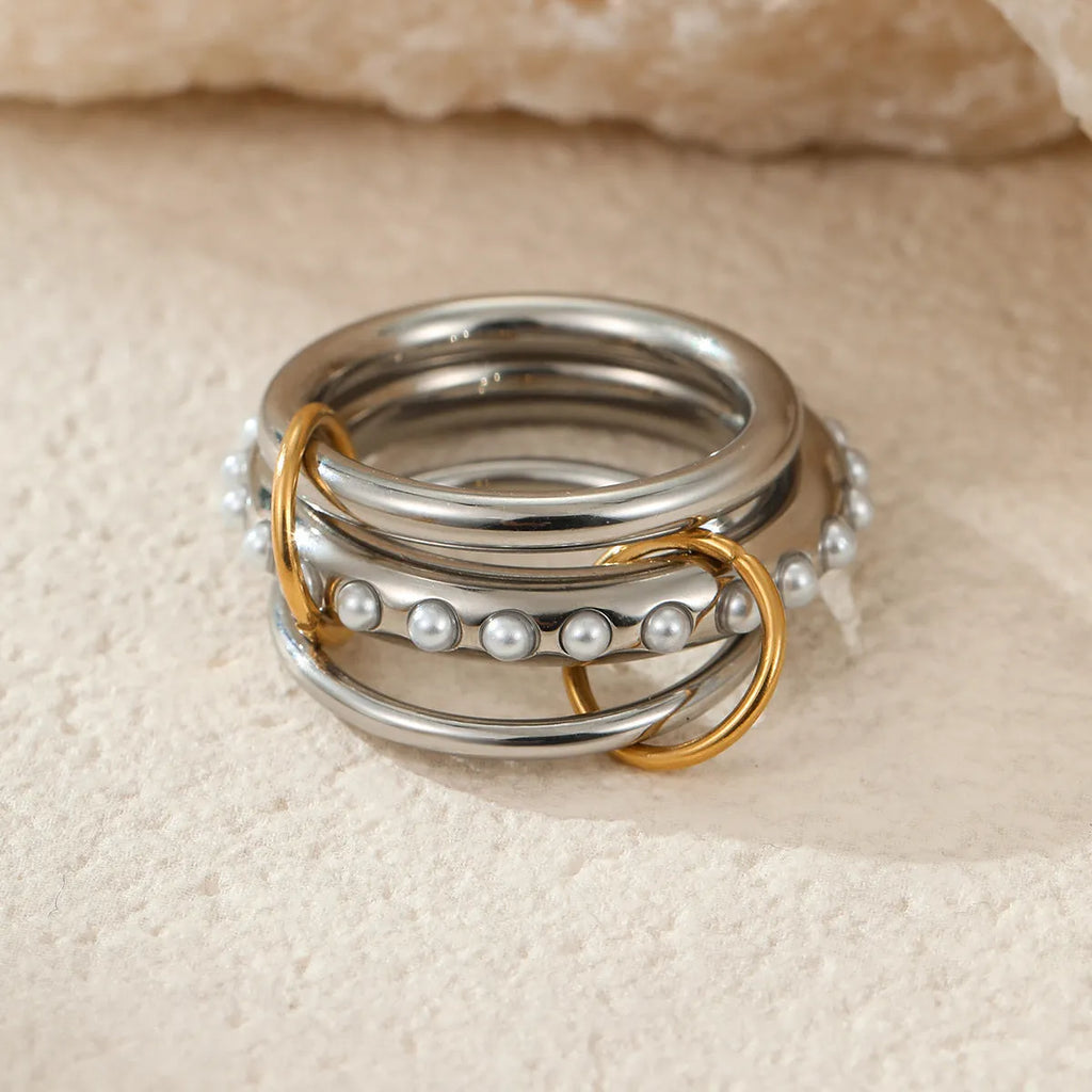 Stacked gold plated stainless steel ring set for women in an exaggerated style on a hand.