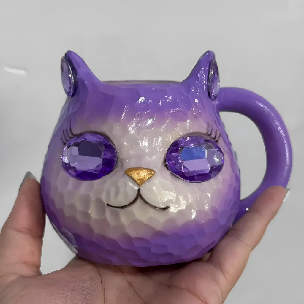 American-style resin ornament of a cat holding a crystal Earth globe in blue, green, pink, or purple.
