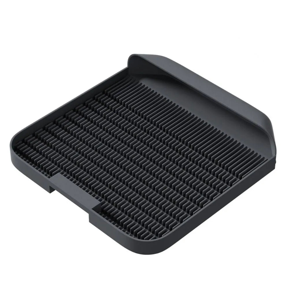Large black cat litter pedal mat with textured grooves, placed next to a litter box.