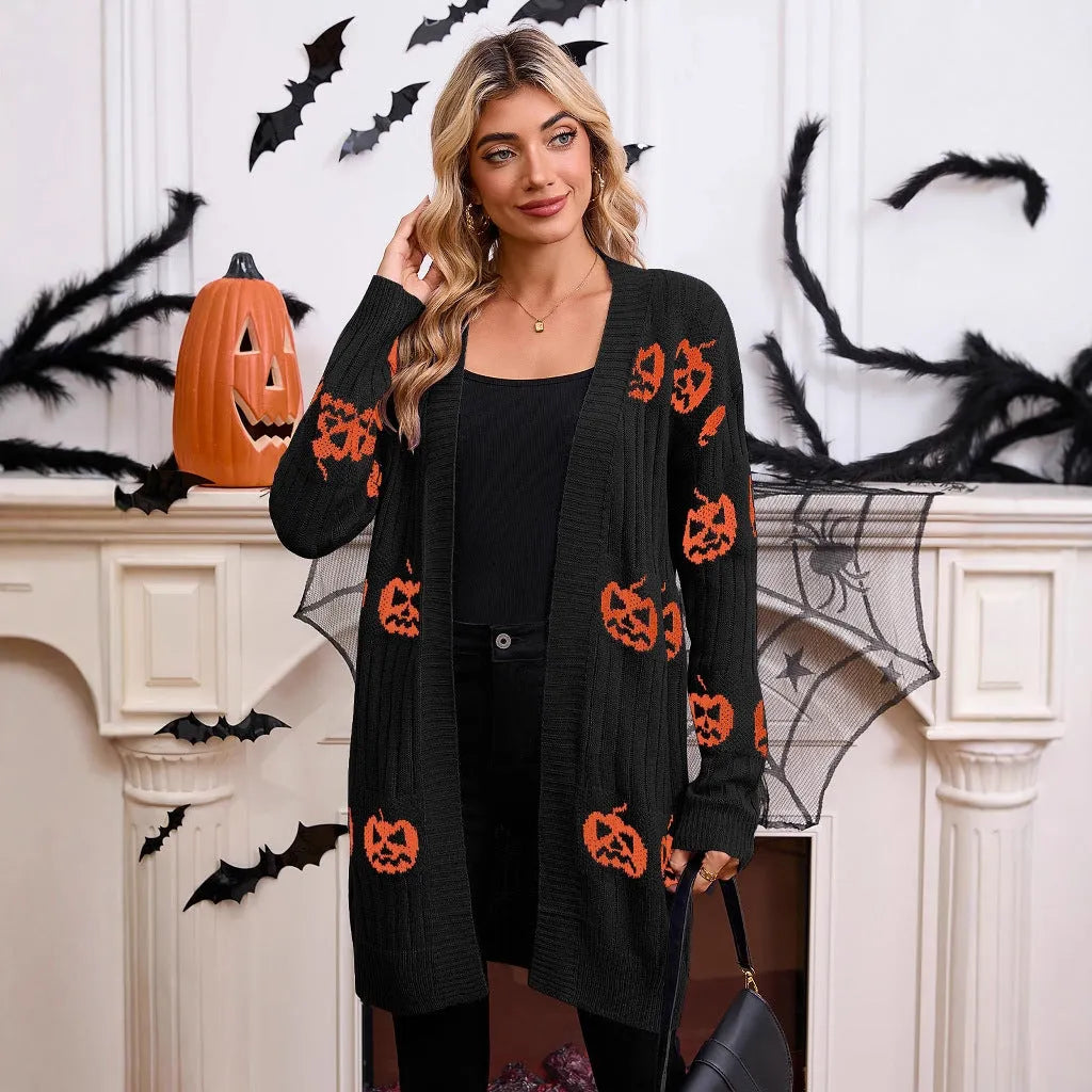 Women's black Halloween cardigan with orange pumpkin head jacquard pattern, shown as a medium-length knitted coat.