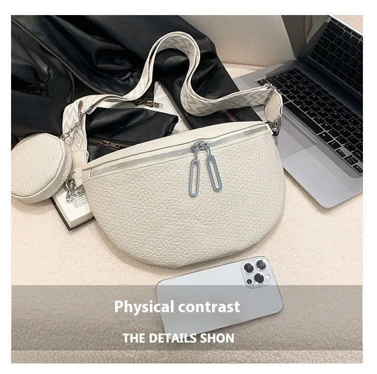 Solid colour women's crossbody bag with saddle lock detail, shown in a horizontal square clamshell shape.