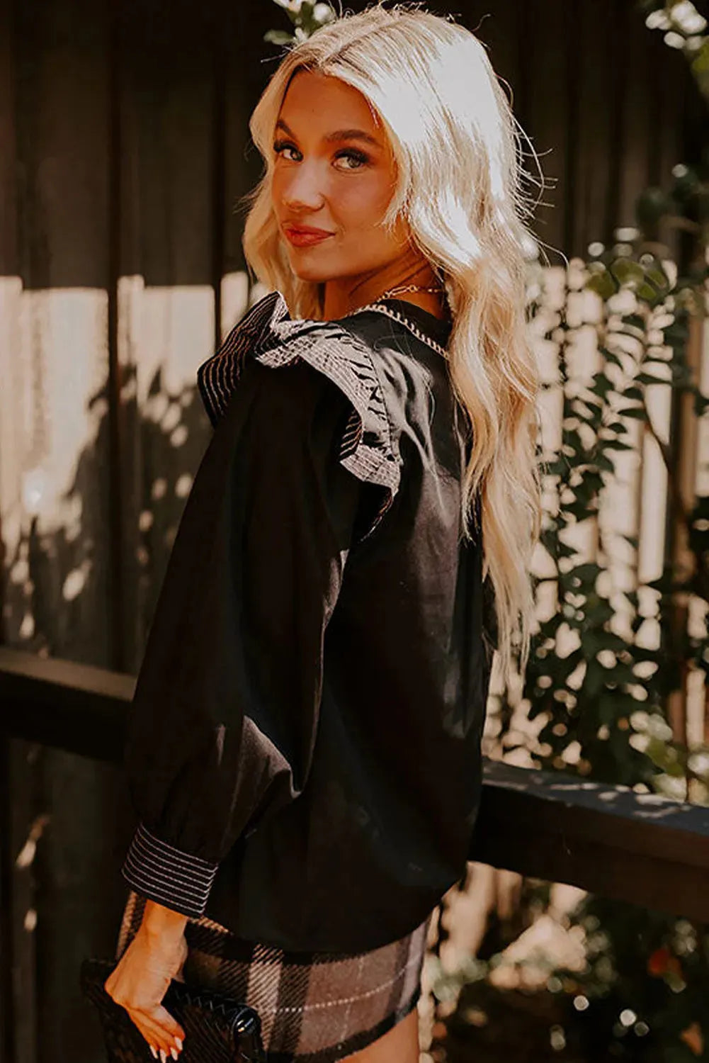 Black long sleeve V-neck blouse with ruffle detail and contrast stitching