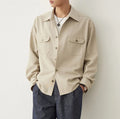 Men's light sand rice coloured long sleeve shirt with a simple lapel collar on a hanger.