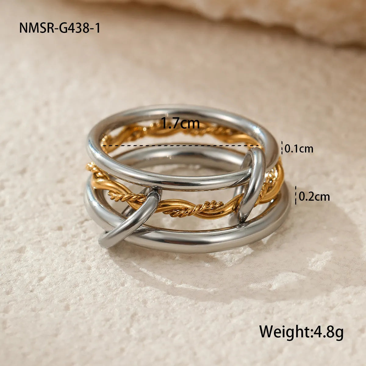 Stacked gold plated stainless steel ring set for women in an exaggerated style on a hand.